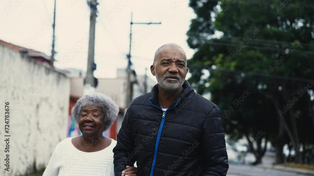 Caring Middle-Aged African American Man Taking a Stroll with His 80-Year-Old Mother in Urban street Setting Caring Middle-Aged African American Man Taking a Stroll with His 80-Year-Old Mother in Urban street Setting
