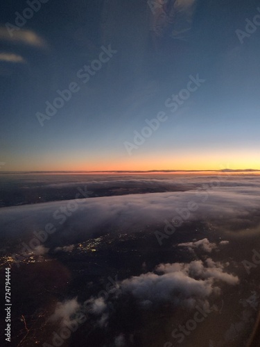 Aerial view at sunset with clouds and sun. Airplane view