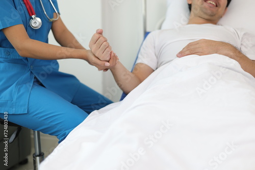 Female doctor visits a male patient in the hospital and discusses their illness and treatment progress. Nurses provide treatment for patients in hospitals.