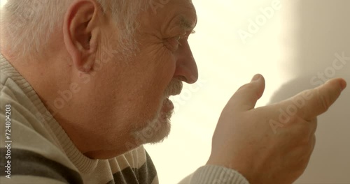 Face close-up. An elderly man engages in effective communication through nonviolent communication, combining verbal and nonverbal cues. He converses articulately, using gestures to enhance expression. photo