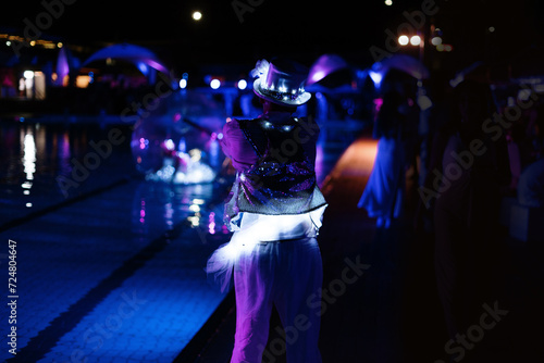 bright dancer by the pool in summer night party