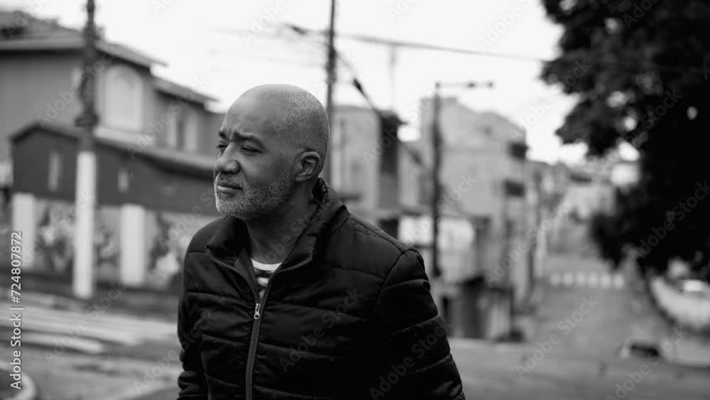 One pensive middle aged black man walking outside in street in ...