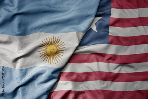 big waving national colorful flag of liberia and national flag of argentina .