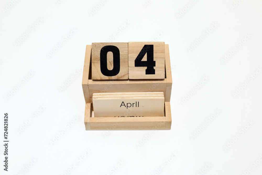 Close up of a wooden perpetual calendar showing the 4th of April. Shot close up isolated on a white background Close up of a wooden perpetual calendar showing the 4th of April. Shot close up isolated on a white background