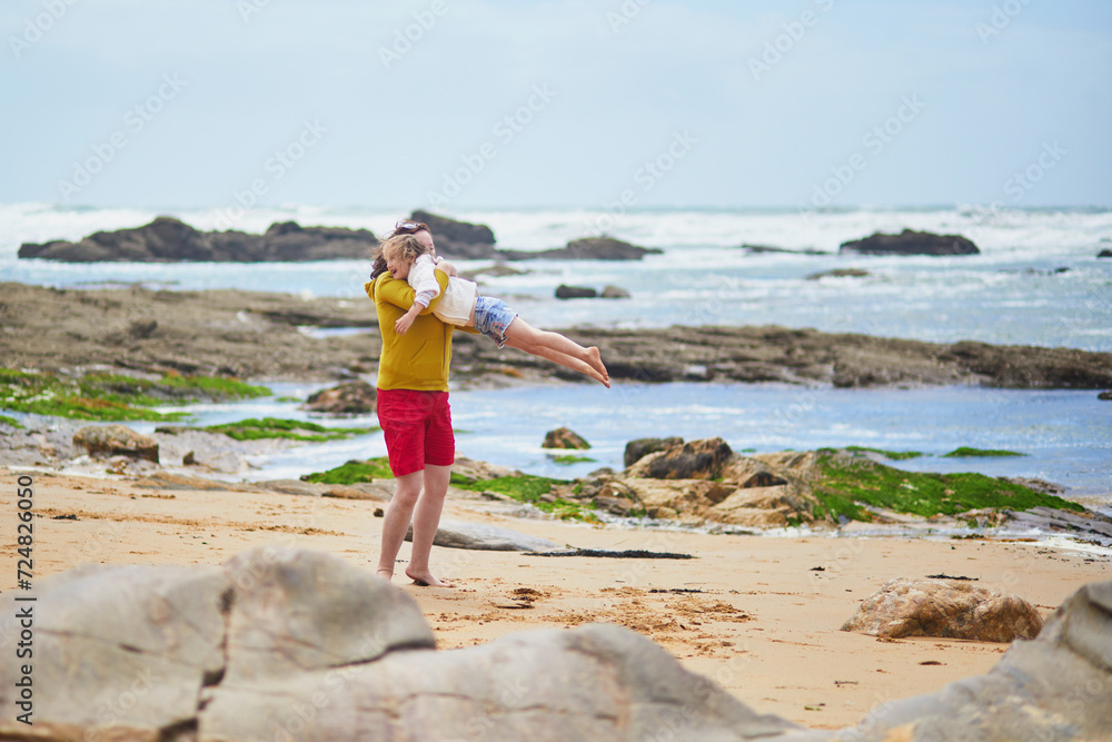 Woman and preschooler girl playing on the beach at Atlantic coast of Brittany, France