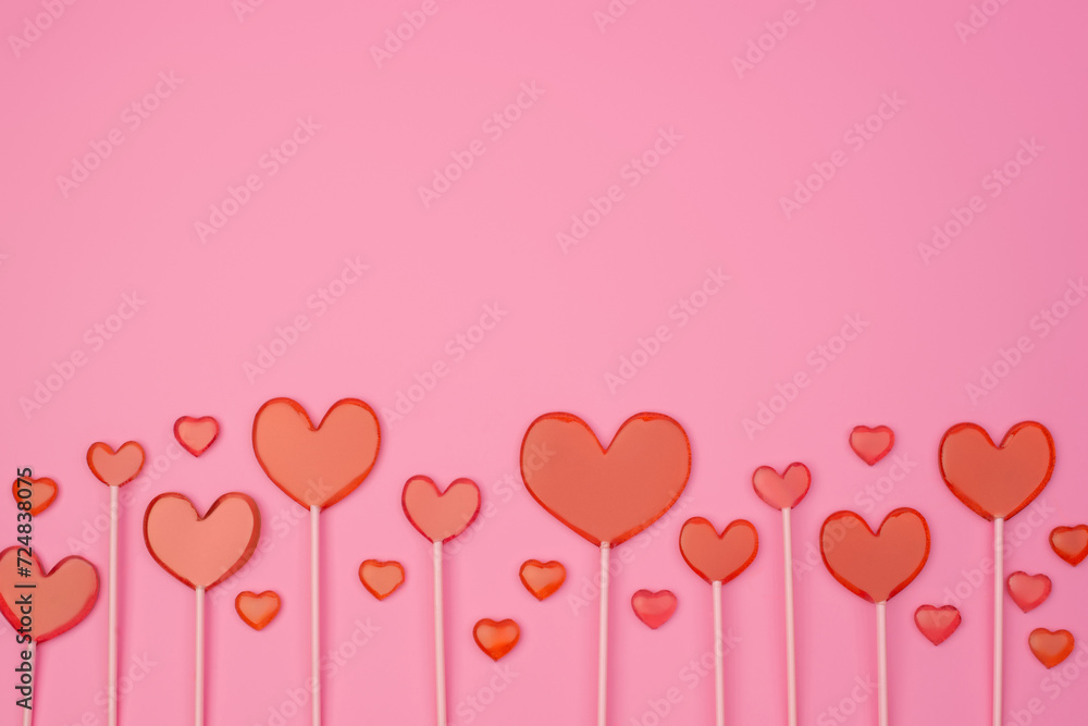 Heart lollipops on a pink background