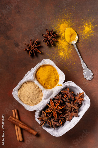 on a rustic background, in a container of eggs, turmeric, ginger powder and star anise.