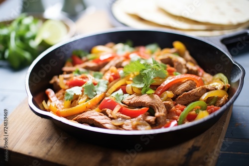 fajitas with sizzling peppers and onions on a castiron pan