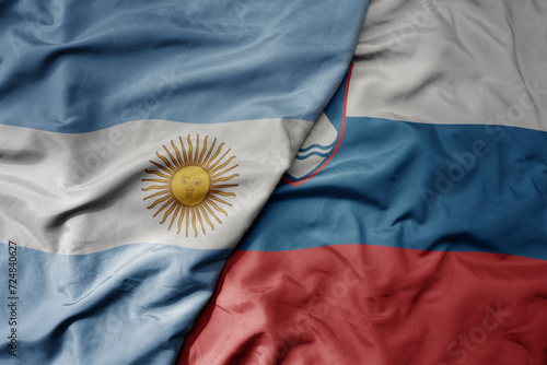 big waving national colorful flag of slovenia and national flag of argentina .