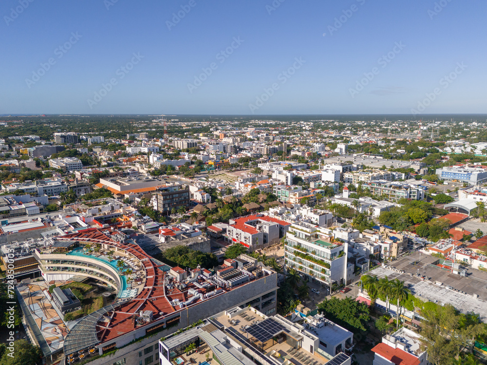 Aerial drone view of Playa del Carmen downtown area with rooftop swimming pools and cloudless blue sky