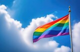 A large rainbow flag flies against the sky