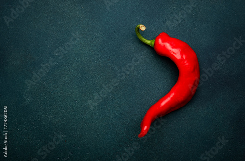 Red chili pepper on deep green background  minimalistic style  top view