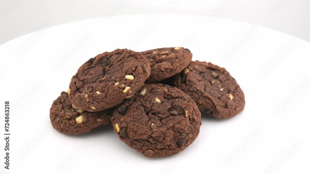 Close-up of a chocolate chip biscuits on a white plate. Rotation. Close-up of a chocolate chip biscuits on a white plate. Rotation.