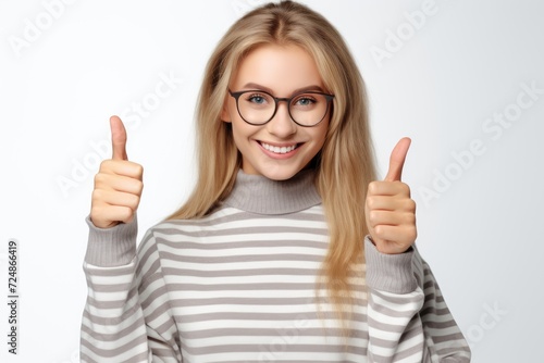 A woman wearing glasses expresses approval and positivity by giving a thumbs up.
