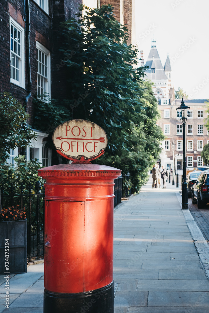 Red post box with a retro Post Office sign in London, UK. Red post box with a retro Post Office sign in London, UK.