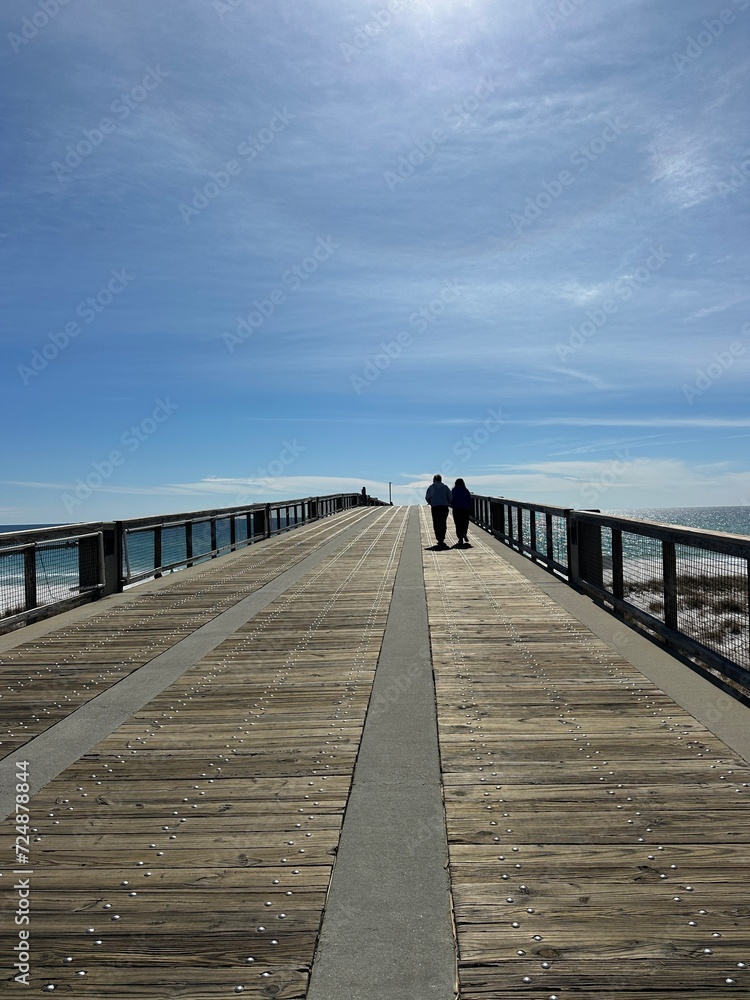 Silhouette people walking on the Navarre Beach Florida fishing pier