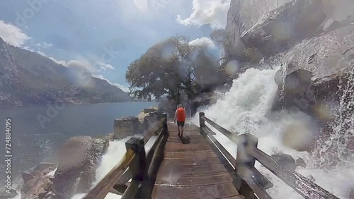 Man Hikes Through Waterfalls Spilling Over Trail in Yosemite
