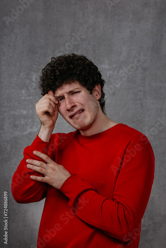 Wallpaper Mural The man in the red sweater is very unhappy, conveys the emotion of grief and despair Torontodigital.ca