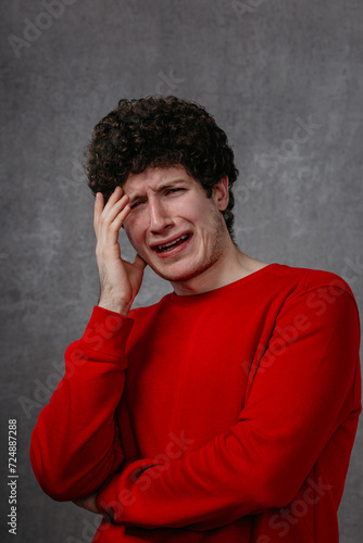 Wallpaper Mural The man in the red sweater is very unhappy, conveys the emotion of grief and despair Torontodigital.ca
