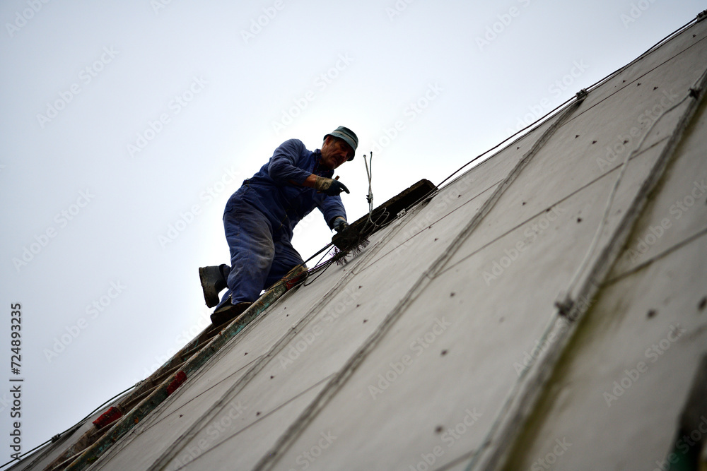 Traditional manual method of cleaning the chimney on the roof
