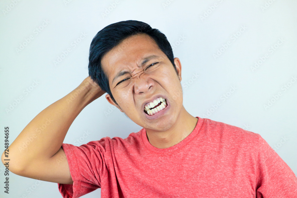 funny facial expression of stressed asian man holding his head, isolated on white background funny facial expression of stressed asian man holding his head, isolated on white background