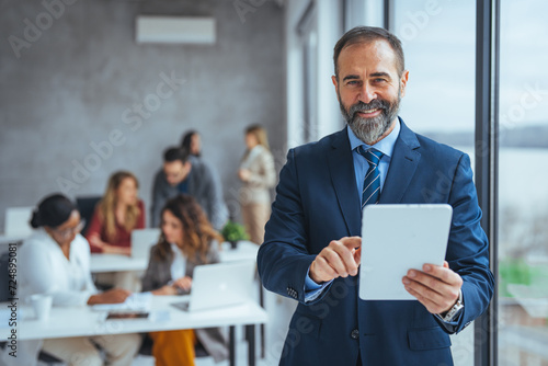 Canvas Print Shot of a successful senior businessman standing in office with digital tablet