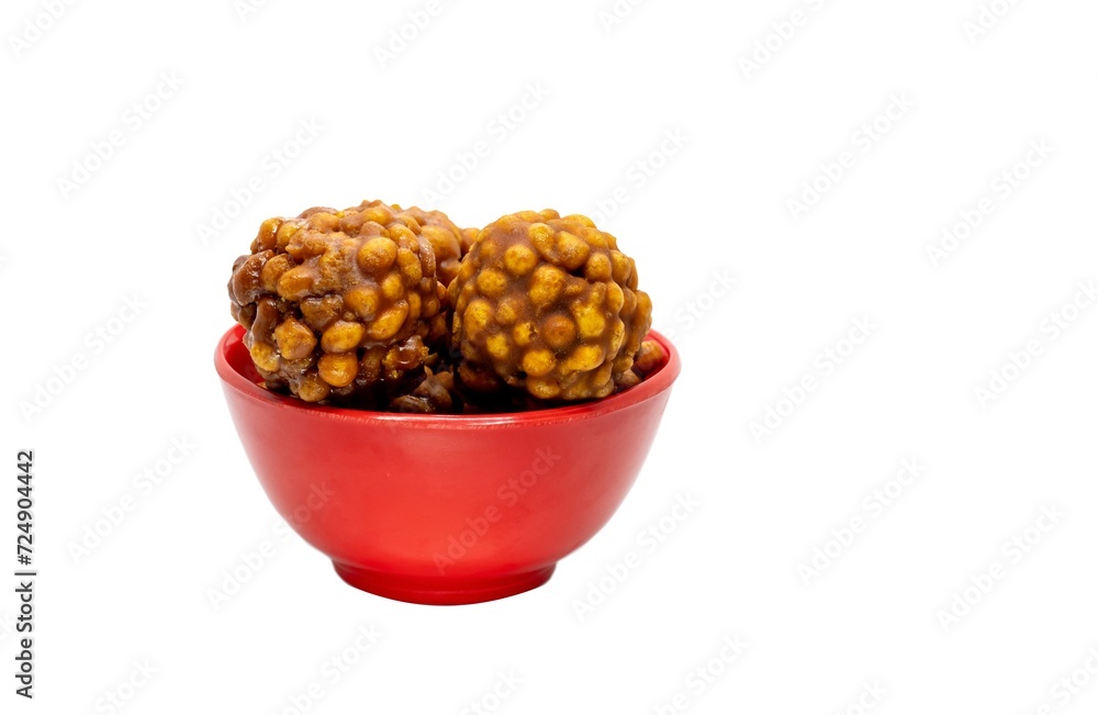 Closeup of Jaggery Laddu or Gur Ladoo Indian Winter Sweets in a Red Bowl Isolated on White Background with Copy Space Closeup of Jaggery Laddu or Gur Ladoo Indian Winter Sweets in a Red Bowl Isolated on White Background with Copy Space