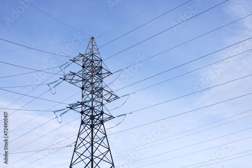 Slika na platnu A high-voltage mast with wires on a background of blue sky with light clouds