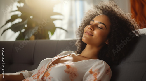 Relaxed serene pretty young woman feel fatigue lounge on comfortable sofa hands behind head rest at home, happy calm lady dream enjoy wellbeing breathing fresh air in cozy home modern living room photo