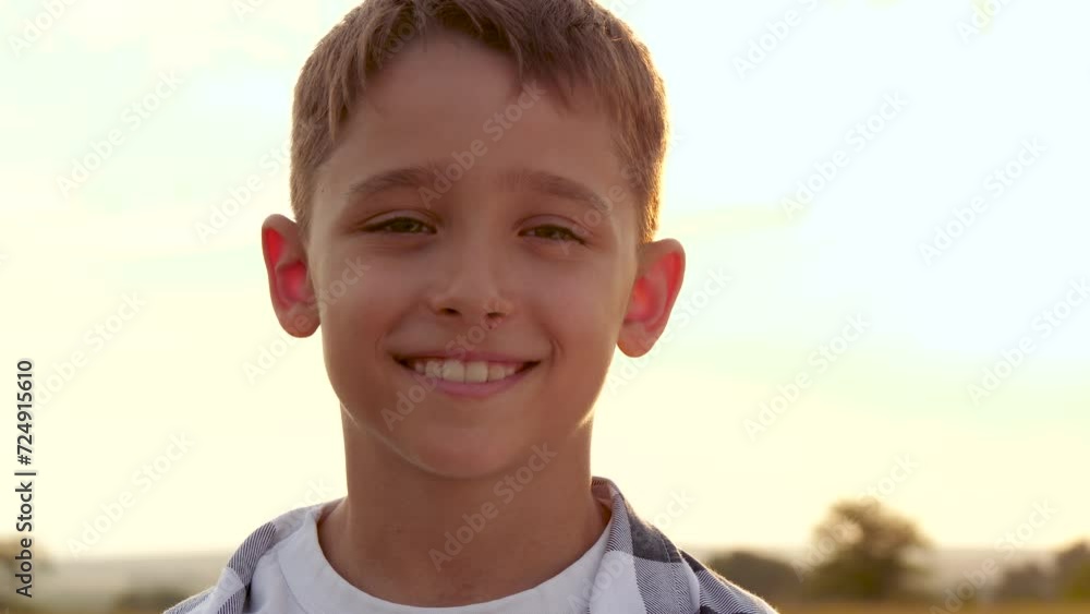 Portrait of a happy boy. Child laughing in the sunlight during sunset or sunrise. A warm summer day. Emotions of children. Expression of Portrait of a happy boy. Child laughing in the sunlight during sunset or sunrise. A warm summer day. Emotions of children. Expression of