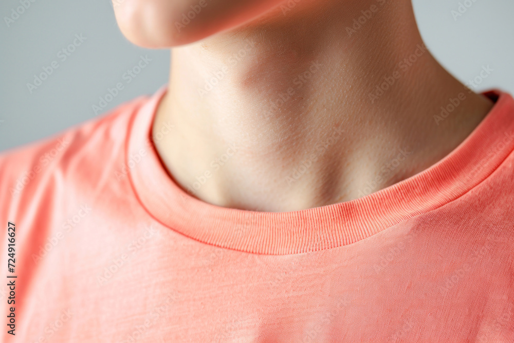 A man in a trendy peach T-shirt. Close up collar.