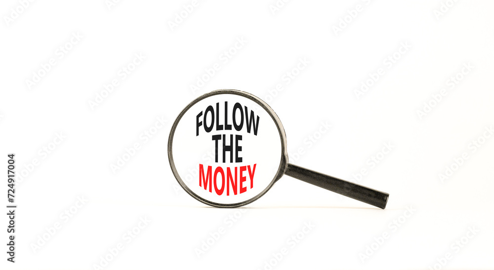 Follow the money symbol. Concept words Follow the money in beautiful magnifying glass. Beautiful white table white background. Business and follow the money concept. Copy space. Follow the money symbol. Concept words Follow the money in beautiful magnifying glass. Beautiful white table white background. Business and follow the money concept. Copy space.