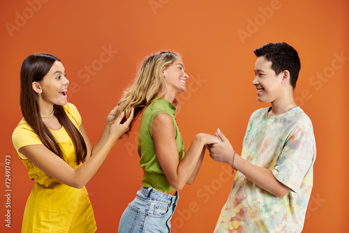 joyous multicultural adolescent friends having great time together and looking at each other