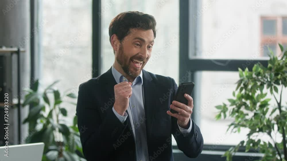 Happy Caucasian man businessman entrepreneur male manager winner reading good news on phone in office promotion at work salary increase winning lottery successful business deal dancing victory dance Happy Caucasian man businessman entrepreneur male manager winner reading good news on phone in office promotion at work salary increase winning lottery successful business deal dancing victory dance