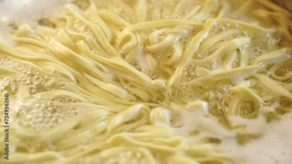 Close-up of homemade pasta in boiling hot water. Metal spoon mixes the pasta in boiling water. 4K Close-up of homemade pasta in boiling hot water. Metal spoon mixes the pasta in boiling water. 4K