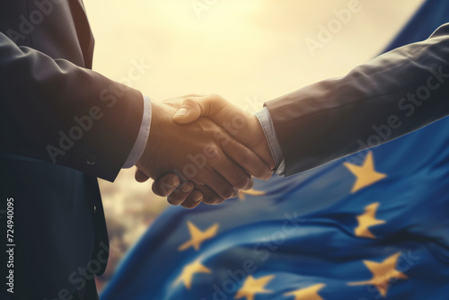 Successful businessmen handshaking after good deal. Business partnership meeting concept. Flag of European Union on a background.