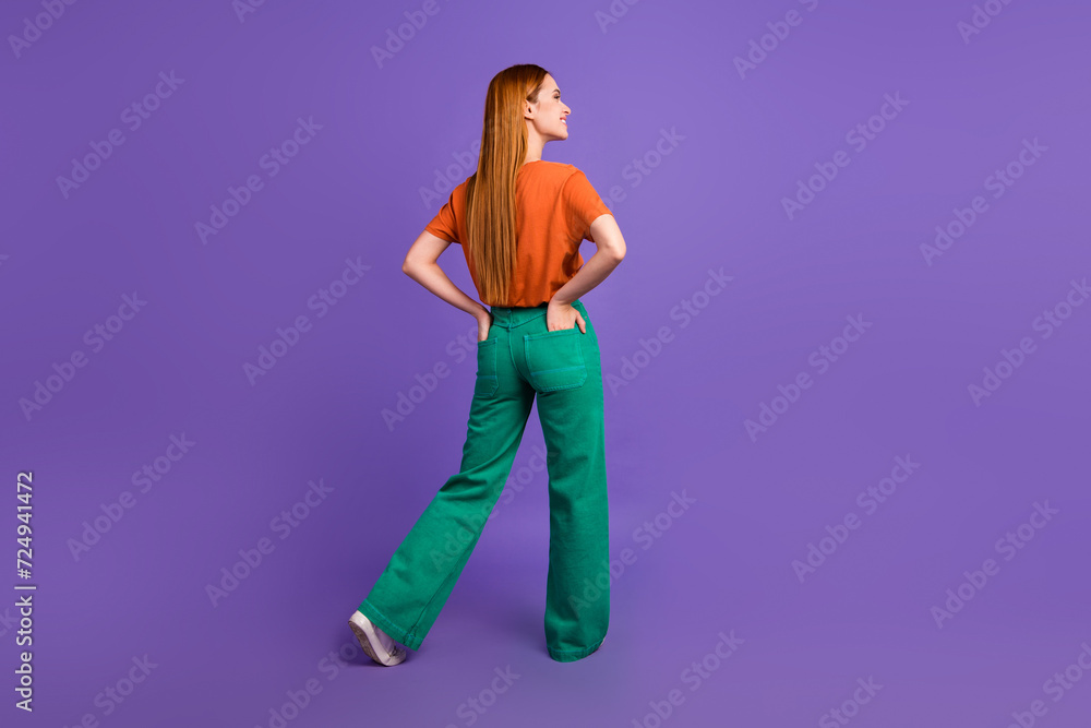 Rear view photo of ginger model girl wearing trendy outfit put hands into pockets look novelty thoughts isolated on violet color background