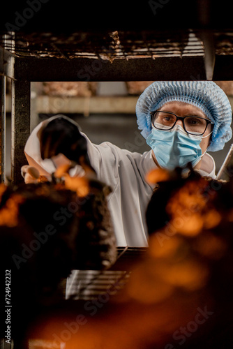 A mycologist in a mask from a mushroom farm grows shiitake mushrooms. A scientist examines mushrooms with a tablet in his hands