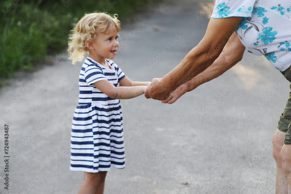 Child with grandmother holding hand. Selective focus. Child with grandmother holding hand. Selective focus.