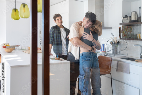 Friends hugging each other happily in light apartment photo