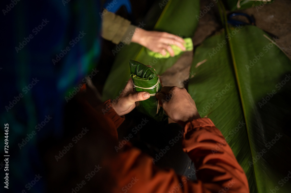 Crop man making banh gio in dark place Crop man making banh gio in dark place