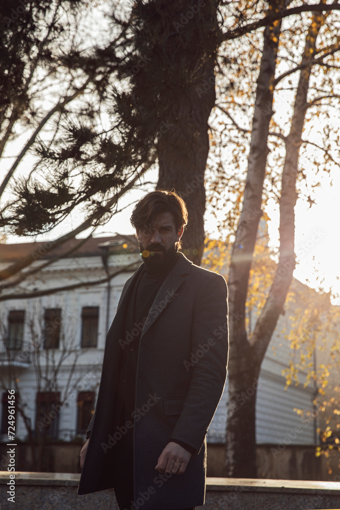 Image of a young bearded posing behind sunset lights.