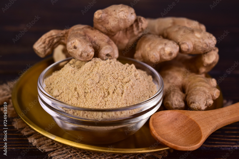 Ginger root and ginger powder in a glass bowl.Close-up. Ginger root and ginger powder in a glass bowl.Close-up.