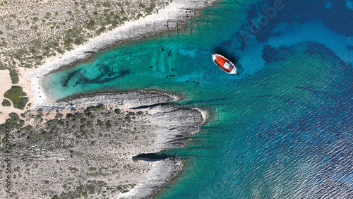 Aerial drone photo of traditional red fishing boat anchored in emelald crystal clear sea caves of Zakynthos island, Ionian, Greece