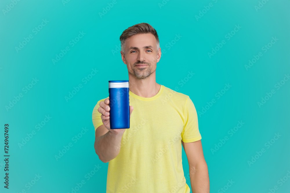 Man with aftershave. Daily habit care. Skincare beauty cosmetic. Shampoo or aftershave. Presenting male cosmetics product. Man use shampoo. Mature man hold hair conditioner. Selective focus Man with aftershave. Daily habit care. Skincare beauty cosmetic. Shampoo or aftershave. Presenting male cosmetics product. Man use shampoo. Mature man hold hair conditioner. Selective focus
