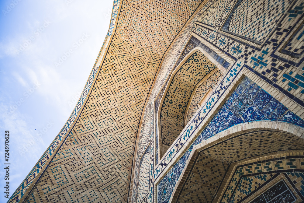 Element of the facade of a madrasah made of brick with mosaic cladding in the ancient city of Bukhara in Uzbekistan, architecture in oriental style, facade of a mosque with patterns and ornaments