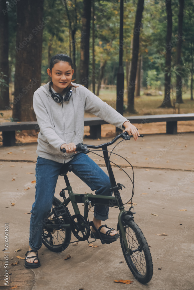 Obraz premium Happy Asian young woman walk and ride bicycle in park, street city her smiling using bike of transportation, ECO friendly, People lifestyle concept.