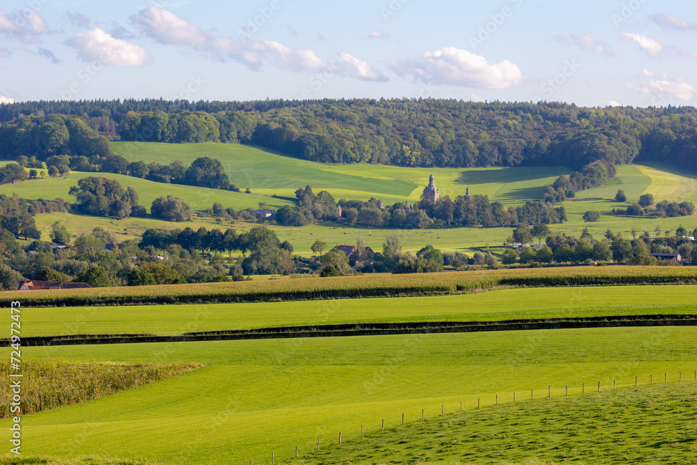 Summer landscape view, Hilly countryside of Zuid-Limburg with small village on the hillside, farmland and forest, Epen is a village in the southern part of the Dutch province of Limburg, Netherlands. Summer landscape view, Hilly countryside of Zuid-Limburg with small village on the hillside, farmland and forest, Epen is a village in the southern part of the Dutch province of Limburg, Netherlands.