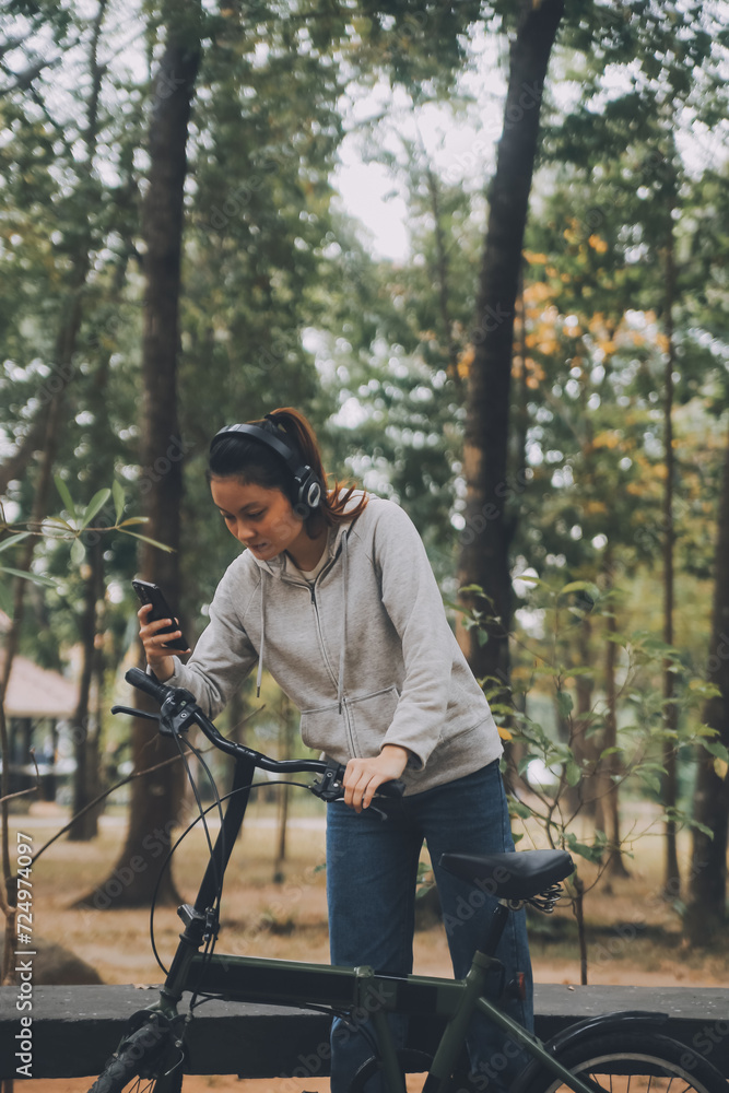 Obraz premium Happy Asian young woman walk and ride bicycle in park, street city her smiling using bike of transportation, ECO friendly, People lifestyle concept.
