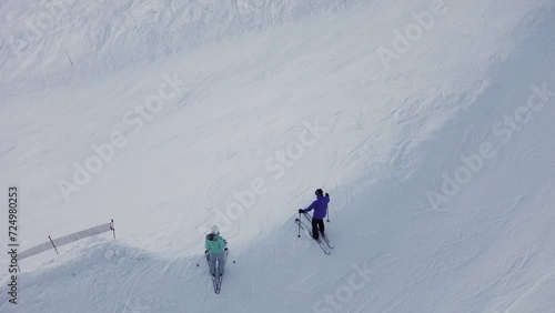 Unrecognized man and woman on ski stand near slope photo